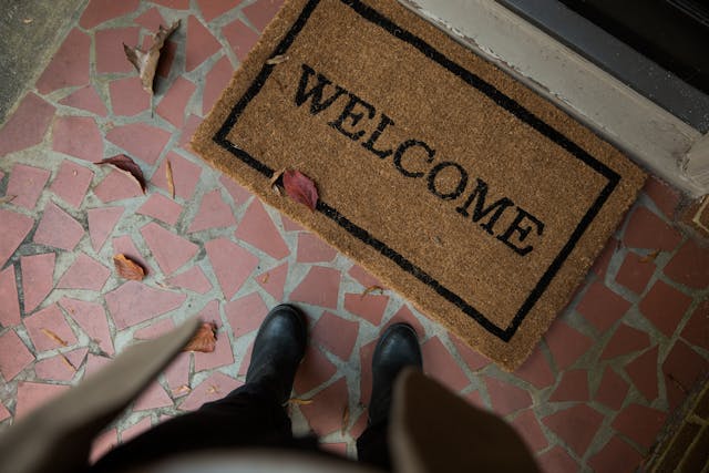 Person standing in front of a welcome mat